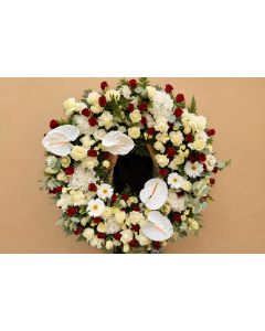 Coroană funerară rotundă cu trandafiri, hortensii și alte flori de sezon